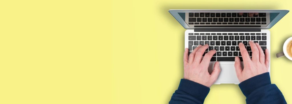 Mains tapant sur un ordinateur portable avec une tasse de café sur un fond jaune