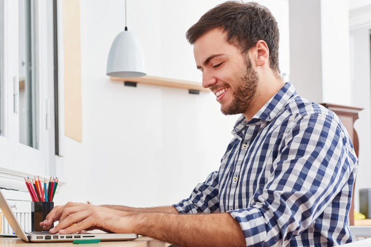 Jeune homme travaillant sur un ordinateur portable