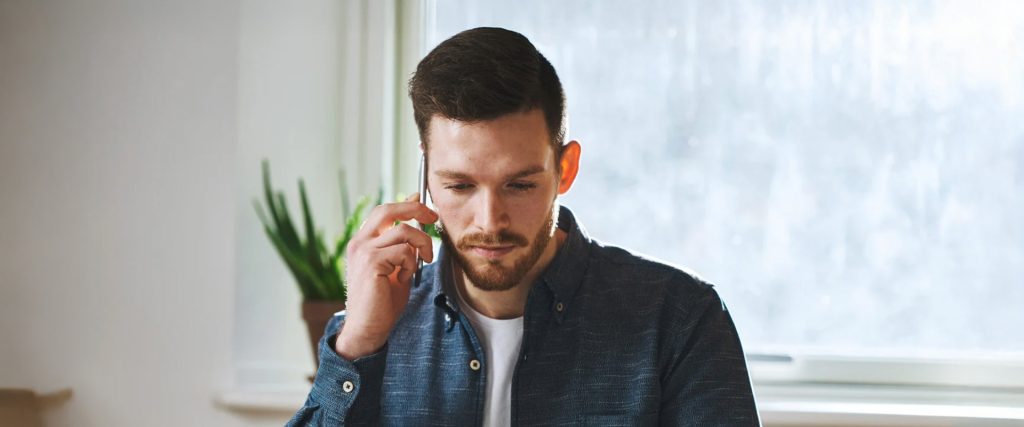 Homme concentré parlant au téléphone dans un bureau lumineux